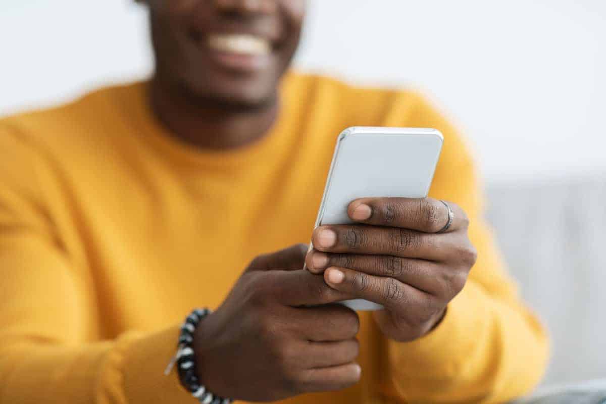 Person with mobile phone wearing yellow shirt